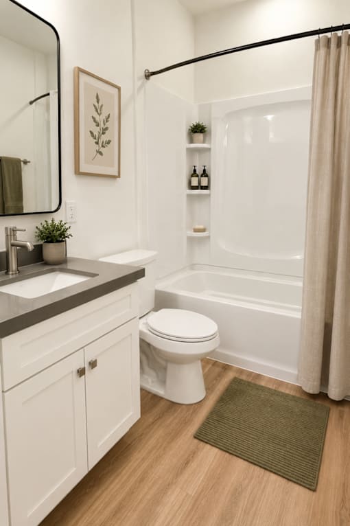 A white toilet sits in a bathroom next to a sink and a bathtub.