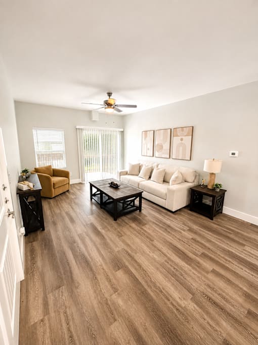 A living room with a white couch and a brown coffee table.