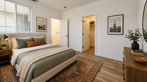 A bedroom with a large bed and a rug on the floor.