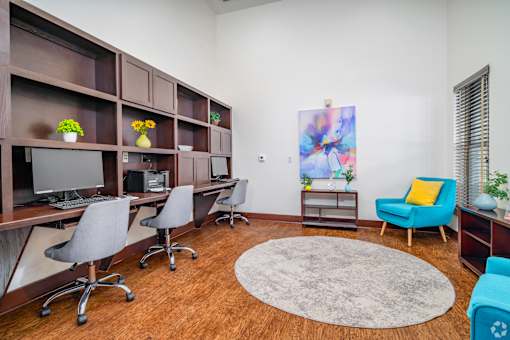 A room with brown shelves, chairs, and a rug at The Villages at Lost Creek Apartments, San Antonio, Texas