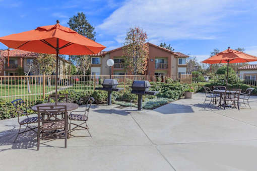 an outdoor patio with tables and chairs and umbrellas at Riverview Springs, Oceanside