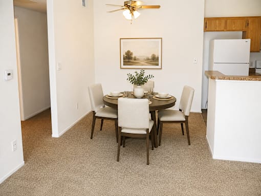 A dining room with a table set for four.