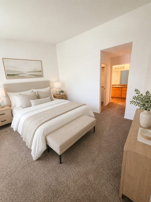 A bedroom with a large bed and a painting on the wall.
