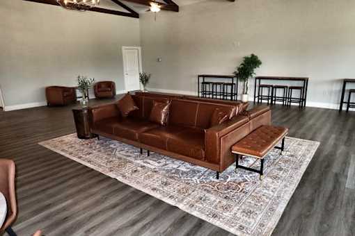 A brown leather couch with a matching ottoman in a room with a rug.