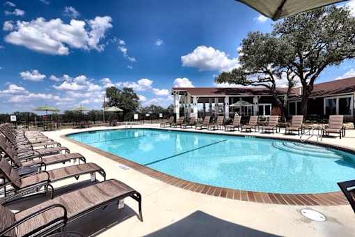 A large outdoor swimming pool surrounded by sun loungers.