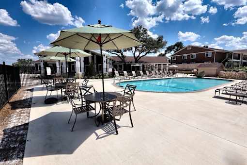 A patio with a table and chairs under an umbrella.