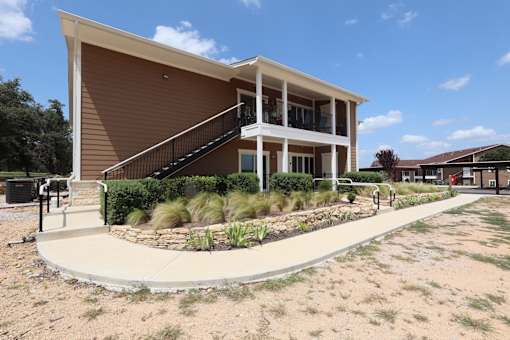 A modern building with a brown facade and a staircase leading to the entrance.