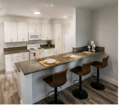 A kitchen with a bar and stools.