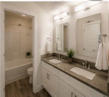 A white bathroom with a toilet, sink, and mirror.