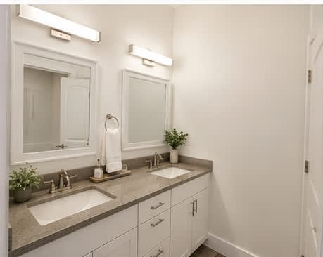 A bathroom with two sinks and a large mirror.