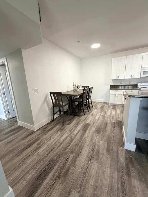 A kitchen with a dining table and chairs.