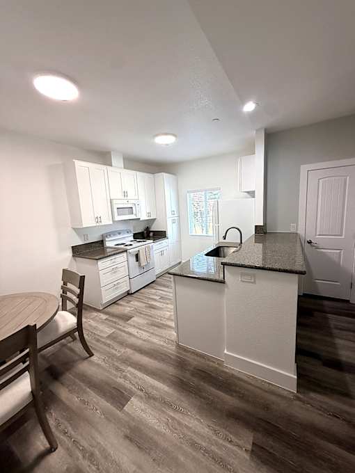 A kitchen with a table and chairs.