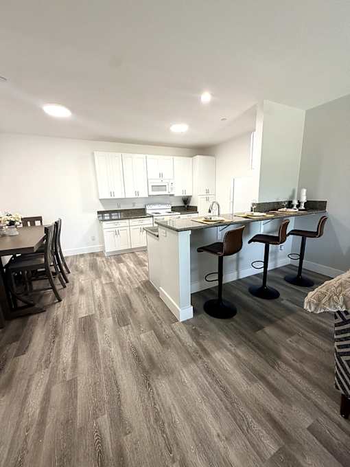 A kitchen with a bar area and chairs.