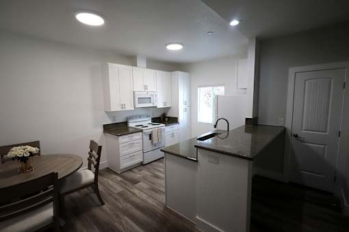 A kitchen with a table and chairs.