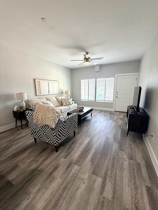 A living room with a sofa, a chair, a coffee table, and a television.