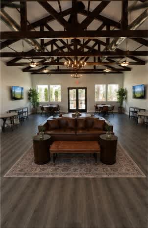 A large room with a wooden floor and a chandelier hanging from the ceiling.