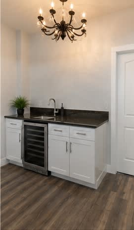 A kitchen with white cabinets and a dark countertop.
