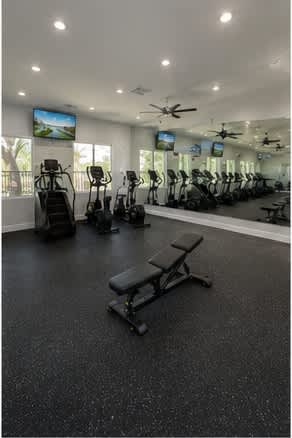 A gym with a variety of equipment including treadmills, exercise bikes, and weight benches.