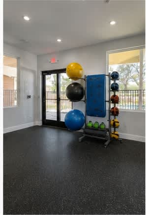 A room with a blue and yellow exercise ball on a stand.