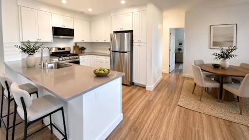 A modern kitchen with a dining table and chairs.