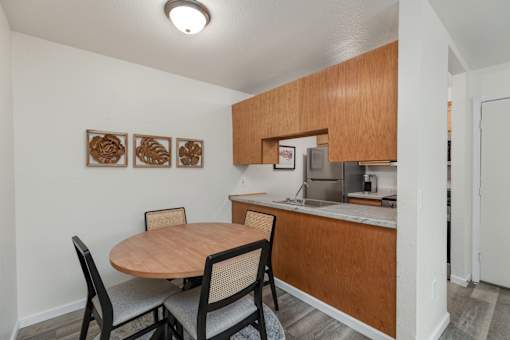 A kitchen with a table and chairs.