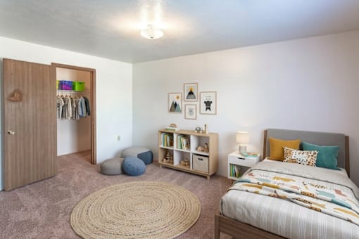A bedroom with a bed, a wardrobe, and a rug.