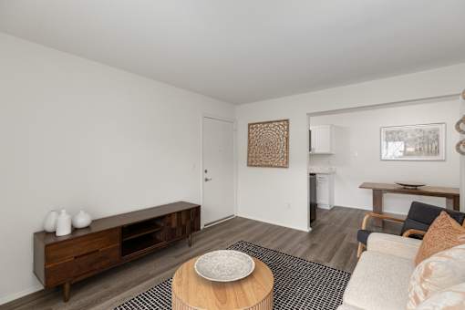 A living room with a brown wooden coffee table and a white sofa.