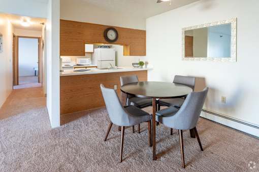 A dining room with a table and chairs.