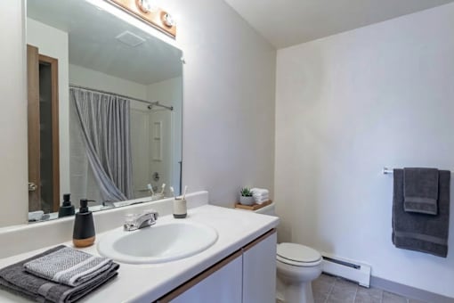 A bathroom with a white sink and a toilet.