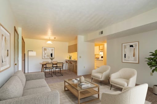A living room with a grey sofa, two chairs and a coffee table.