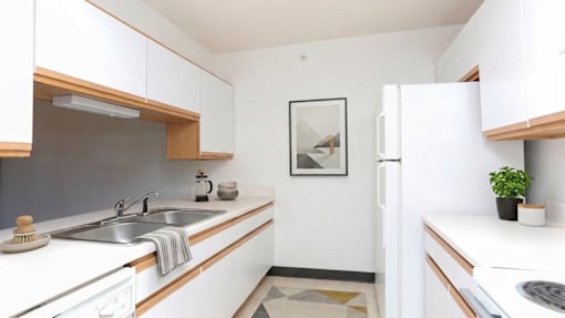 A kitchen with white cabinets and a fridge.