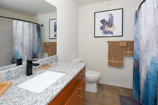 A bathroom with a toilet, sink, and shower curtain.