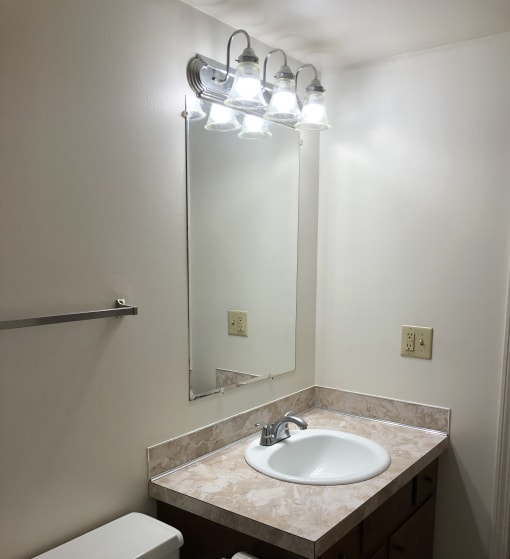 a small bathroom with a sink and mirror