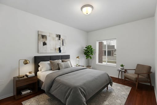 A bedroom with a large bed and a chair.