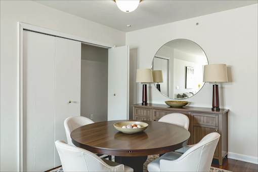 A dining room with a round table and chairs.
