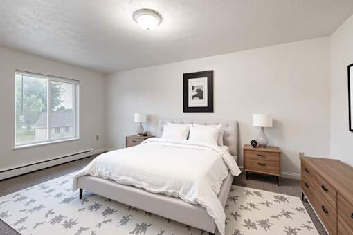 A bedroom with a large bed, two nightstands, and a framed picture on the wall.
