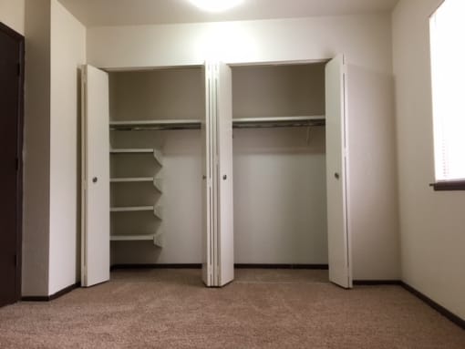 an empty closet in a room with open doors