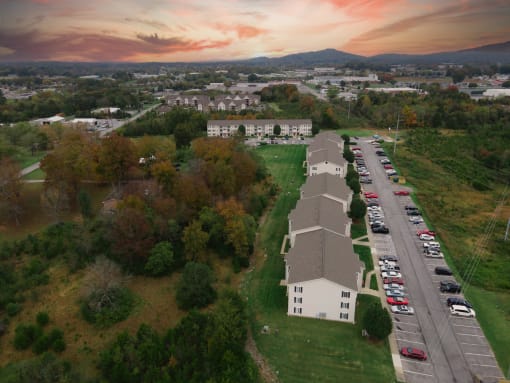 an aerial view of a church and a parking lot with a sunset in the background