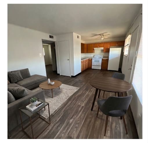 A living room with a grey couch, a coffee table, and a dining table.