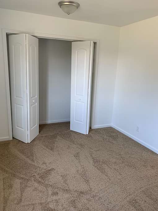 a bedroom with a carpeted floor and two doors