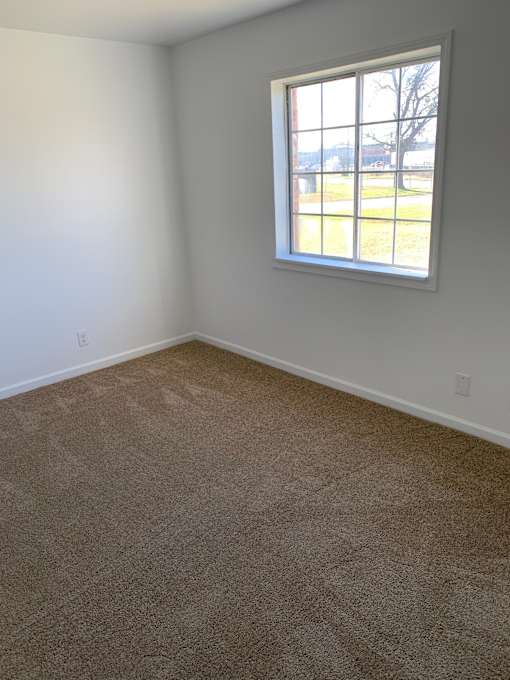 an empty room with carpet and a window