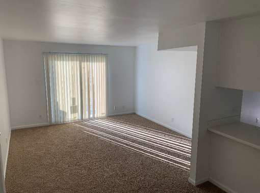 an empty living room with a sliding glass door