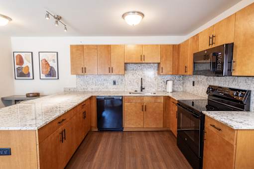 A kitchen with wooden cabinets and a granite countertop.