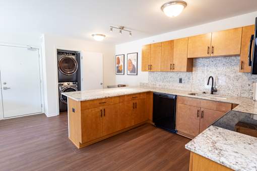 A kitchen with wooden cabinets and a marble countertop.