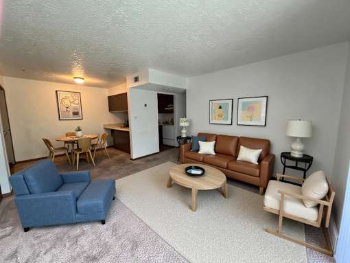A living room with a blue couch, a wooden coffee table, and a lamp.