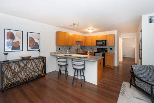 A kitchen with a bar and chairs.