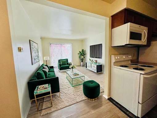 A living room with a green ottoman and a white stove.