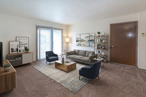 A living room with a blue chair and a grey sofa.