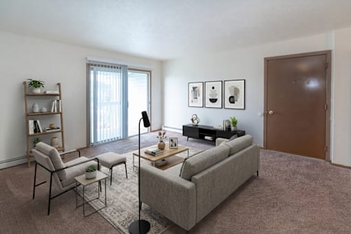 A living room with a grey couch, a chair, a small table with a lamp and a potted plant.