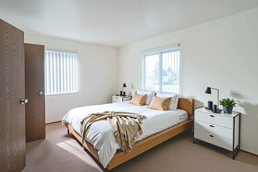 A bedroom with a bed, nightstand, and window.